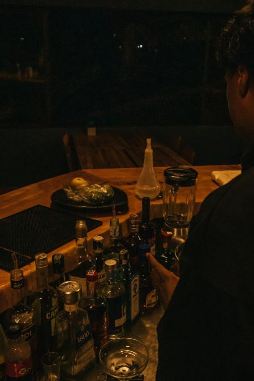 a table with a bunch of bottles and glasses on it at Soy Local Guatape in Guatapé