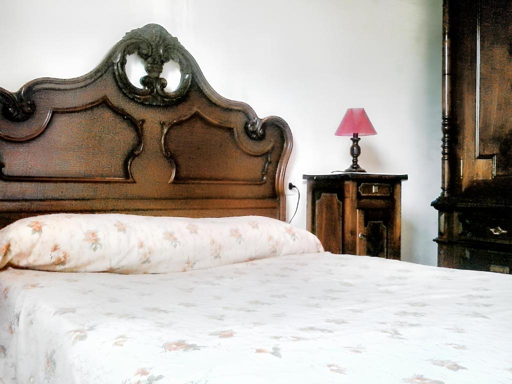 4 bedrooms house with furnished garden at Ourol في Merille: سرير مع اللوح الأمامي الخشبي والوسادة عليه