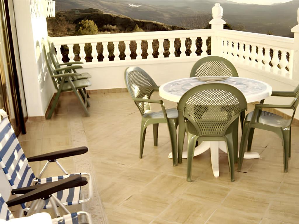 een patio met een tafel en stoelen op een balkon bij 4 bedrooms house with furnished terrace at Yegen in Yegen