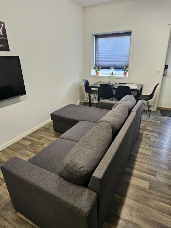 un soggiorno con un divano e un tavolo con sedie di TromsøApartment Silent area with free parking I have caravan for rent same place, 4 people a Tromsø