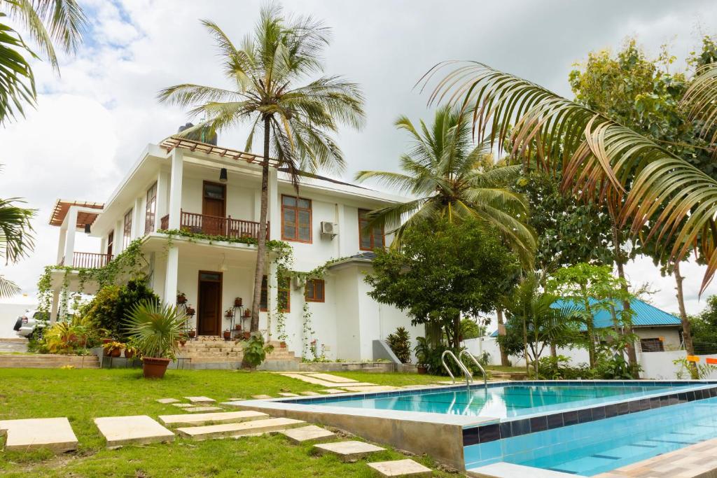 a villa with a swimming pool in front of a house at Getaway Experience Villa. in Dar es Salaam