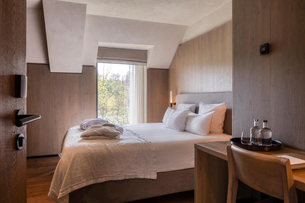 a bedroom with a bed and a desk and a window at Château de Vignée in Rochefort