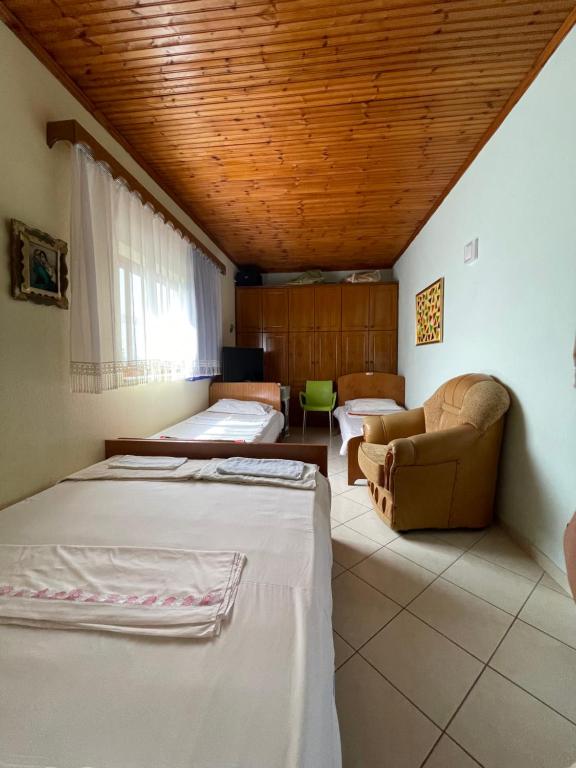 a room with three beds and a couch at Villa Mance in Berat