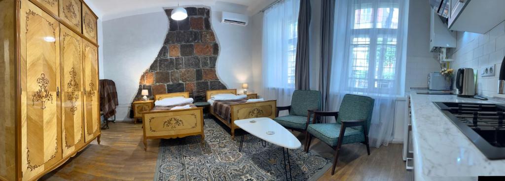 a kitchen with a living room with a table and chairs at Apartments Pushkin Street in Yerevan