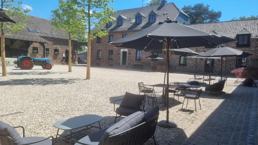 a patio with tables and chairs and an umbrella at Hotel Lohauser Hof in Düsseldorf