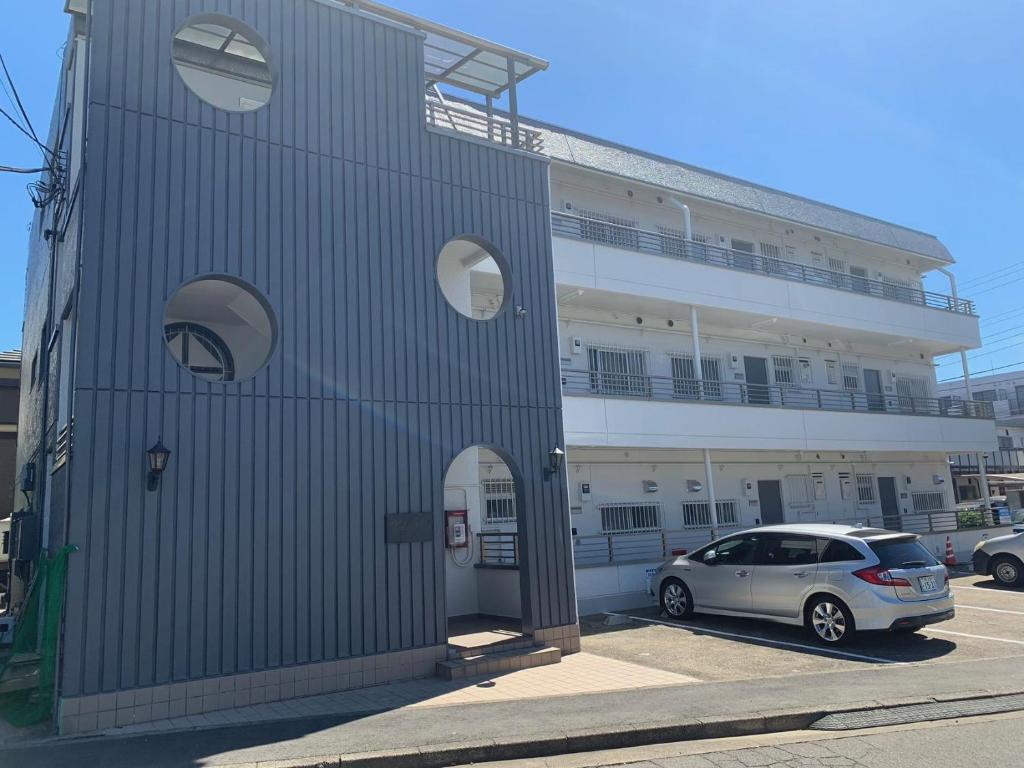 a car parked in front of a building at 丸々貸切HYGGE HOUSE アメニティ完備 キッチン調理器具 高速Wi-Fi 駐車無料 JR北柏駅徒歩2分 上野駅まで30分 成田や羽田空港から60分 in Kashiwa