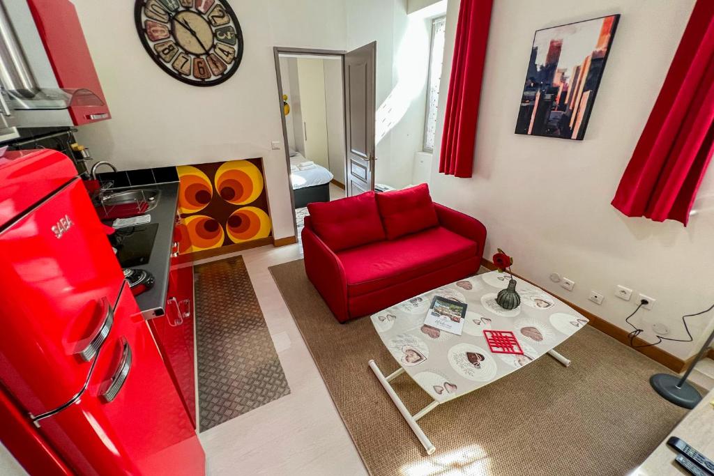 un salon avec un canapé rouge et une table dans l'établissement Coeur de fête, Quartier des Artistes, à Avignon