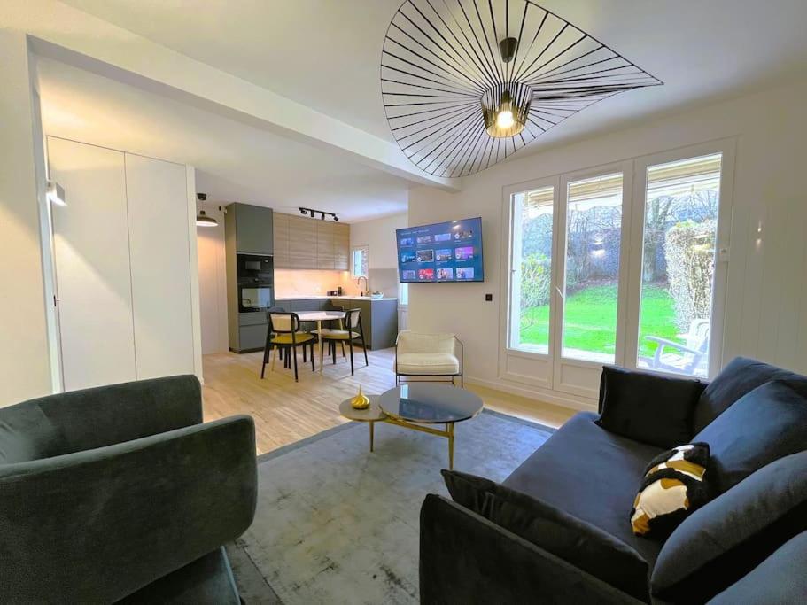 un salon avec un canapé et une table dans l'établissement Le jardin de Deauville, à Deauville