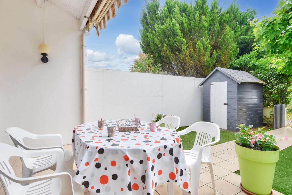 d'une table avec un chiffon de polka sur une terrasse dans l'établissement Escapade avec jardin à 5 min de la plage, à La Parée Preneau