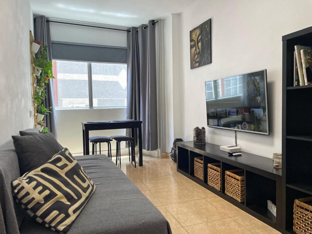 sala de estar con sofá y TV en BKD1 - Apartamento entero a 50 metros PLAYA DE LAS CANTERAS, en Las Palmas de Gran Canaria