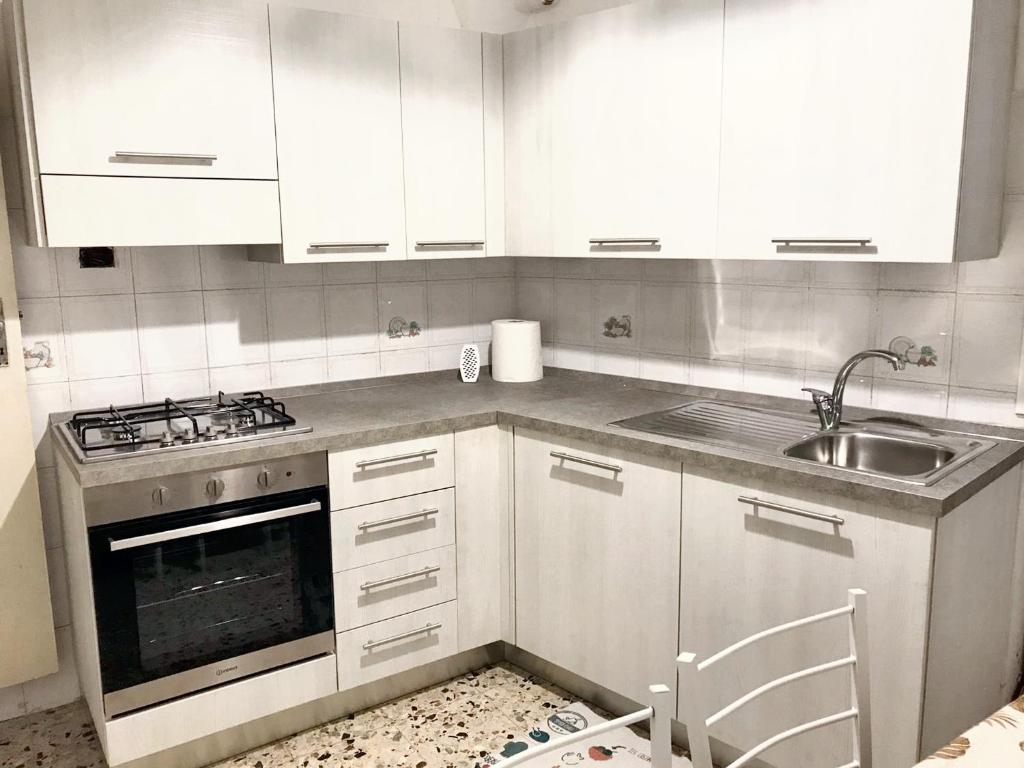 eine Küche mit weißen Schränken und einem Waschbecken in der Unterkunft 2 bedrooms house at Badalucco 8 km away from the beach in Badalucco