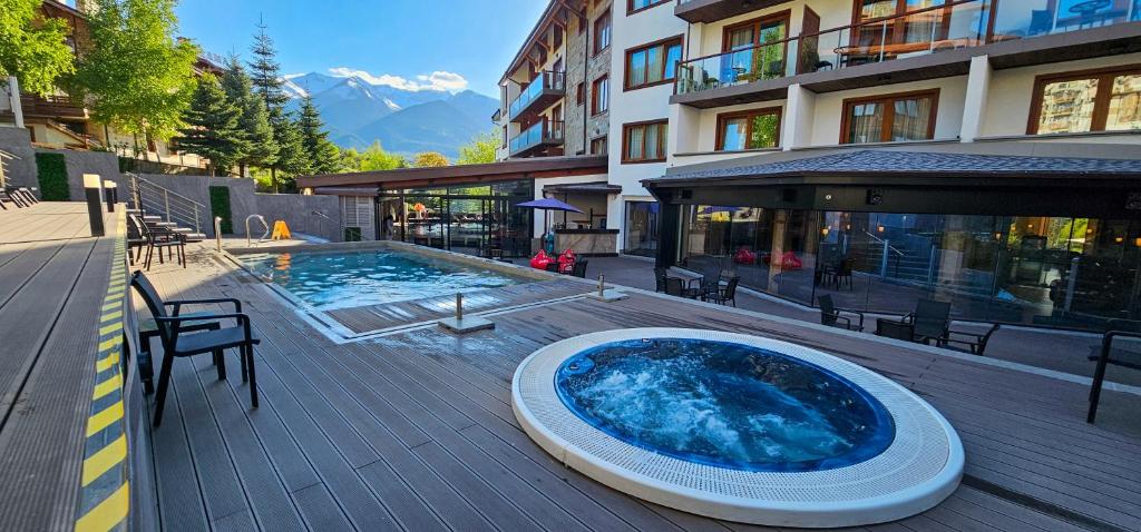a large hot tub sitting on a deck next to a building at Apartmanica Double room apartment with balcony, St Ivan Rilski 4 star SPA Resort, Bansko in Bansko