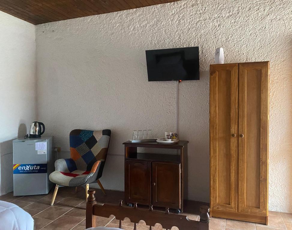 a room with a desk and a tv on the wall at Posada TyM in Trinidad
