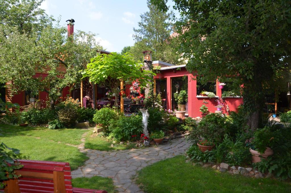 una casa roja con un jardín delante en Rotes Kreativ-Ferienhaus en Bad Lausick