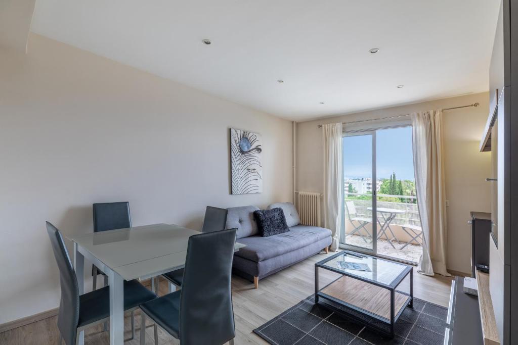un salon avec une table et un canapé dans l'établissement Vue mer, Terrasse, 5 min du centre, à Antibes