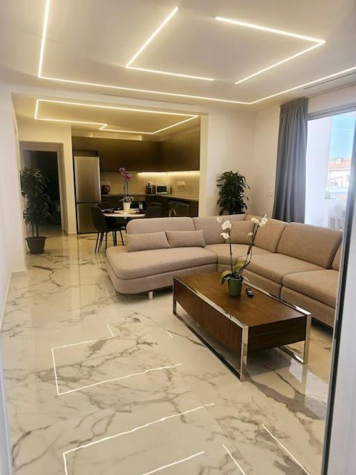 a living room with a couch and a table at DELUXE APARTMENT in Paphos City