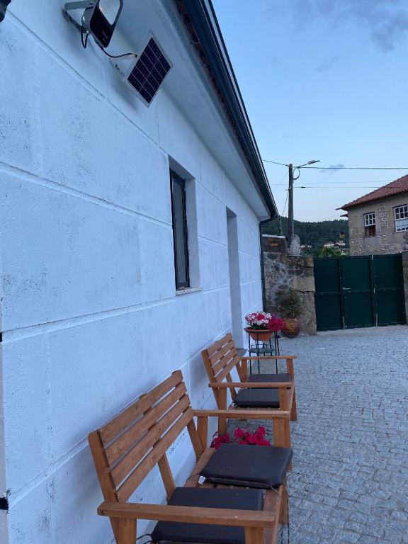 drei Holzbänke neben einem Gebäude in der Unterkunft Casa da Quinta da Mata in Cabeceiras de Basto