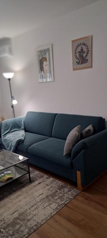 un sofá azul sentado en una sala de estar en Apartman Moonlite en Čakovec