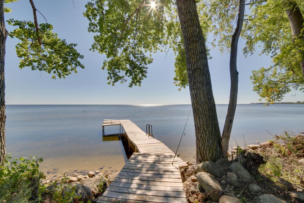 un quai en bois s'étend dans l'eau dans l'établissement Cozy Cottage with 600 of Green Bay Frontage and Dock!, à Oconto