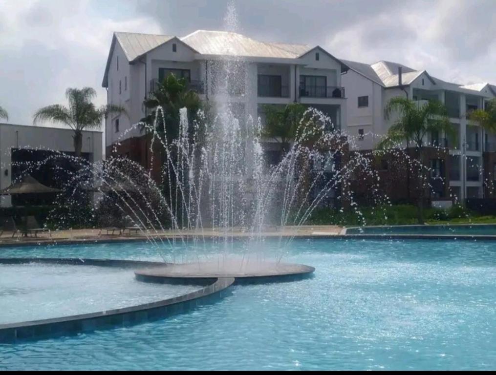 a fountain in the water in front of condos at The Blyde Crystal Lagoon in Pretoria