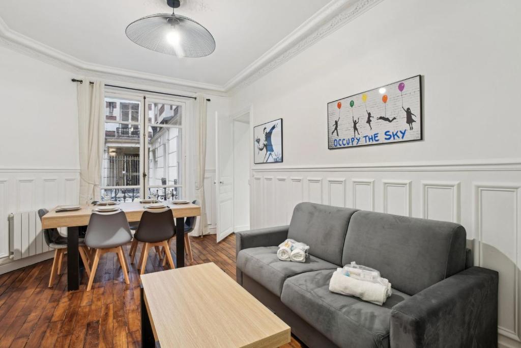 un salon avec un canapé et une table dans l'établissement 523 Suite Batignolles - Superbe Appartement, à Paris