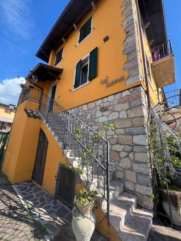 a yellow building with stairs in front of it at Caivano Rooms New Opening in Torri del Benaco