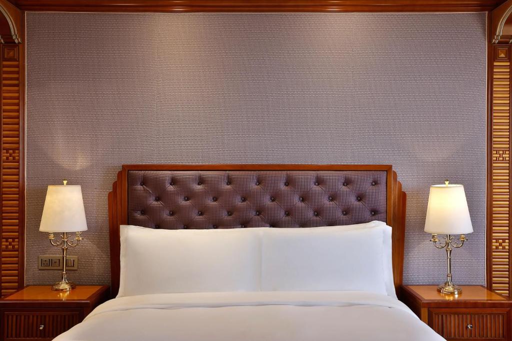 a bedroom with a large bed with two lamps at The Ritz-Carlton Jeddah in Jeddah