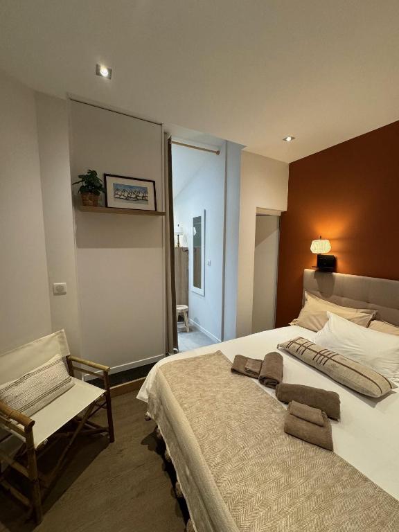 une chambre avec un grand lit et une chaise dans l'établissement maison belle rade : l'amarre, à Dunkerque