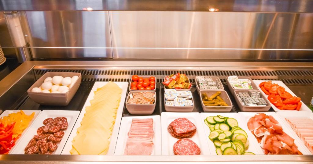 a bunch of different types of food in a refrigerator at Mandarina Hotel Luxembourg Airport in Luxembourg
