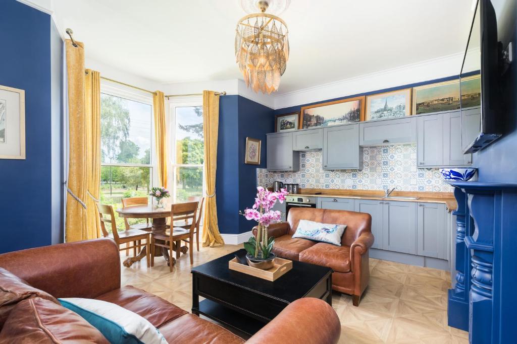 a living room with a couch and a table at Spa Villas Boutique Apartments in Gloucester