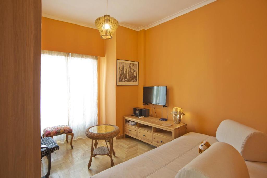 een woonkamer met een bank en een tv bij Sunny View in Koukaki in Athene