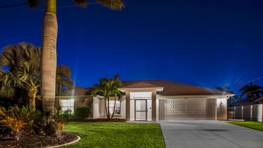 a house at night with a palm tree at Belloccia With Pool And Spa Best Boating Location in Cape Coral