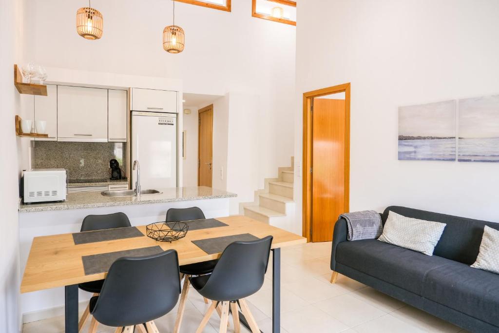 een woonkamer met een tafel en stoelen en een bank bij Ca lEudald 3 Apartamento en Besalú con terraza in Besalú