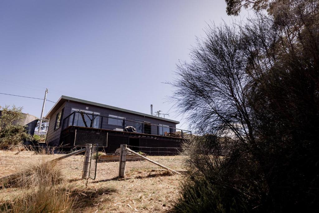 a house sitting on the side of a field at 'Lazy Susan's' Waterfront Shack in Primrose Sands