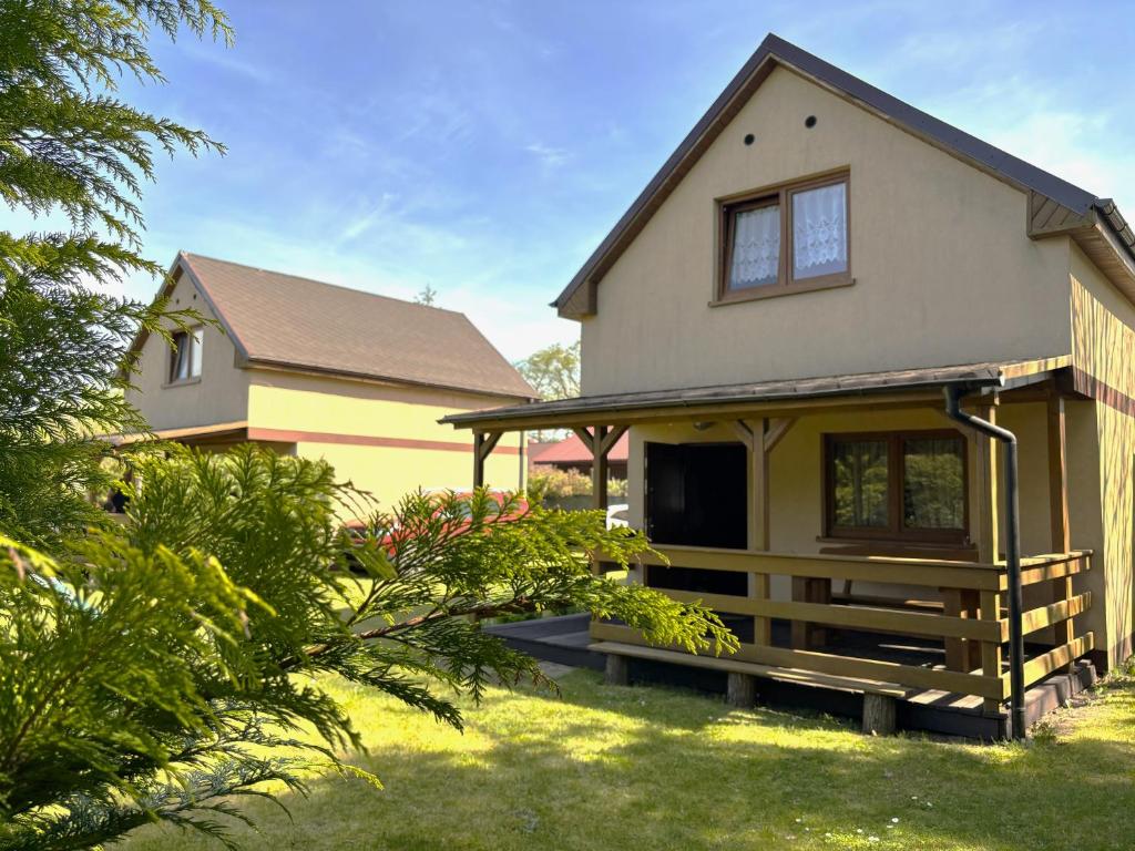 a yellow house with a porch in a yard at Kopalino 7th Heaven in Kopalino