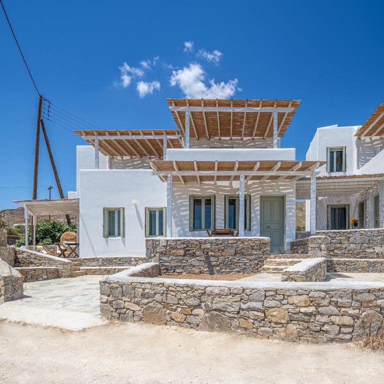 a white house with a stone wall at Sea Houses SERIFOS in Rámos
