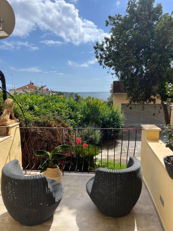 two black wicker chairs sitting on a patio at Rosina Apartament il corso in Torre del Greco