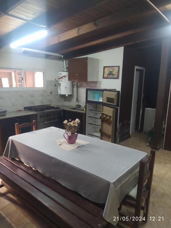 a kitchen with a table with a vase of flowers on it at Loft Necochea in Necochea