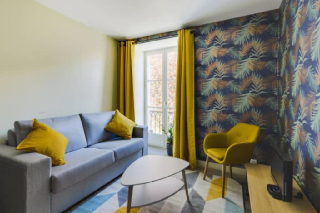 un salon avec un canapé bleu et un fauteuil jaune dans l'établissement Suite L'Ambassade - Second Lodge - Hyper Centre, à Rennes
