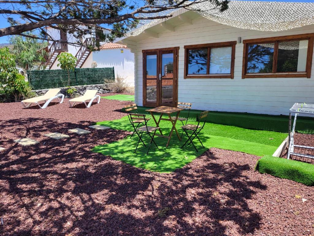 un patio con mesa y sillas frente a una casa en Preciosa cabaña en Guía de Isora