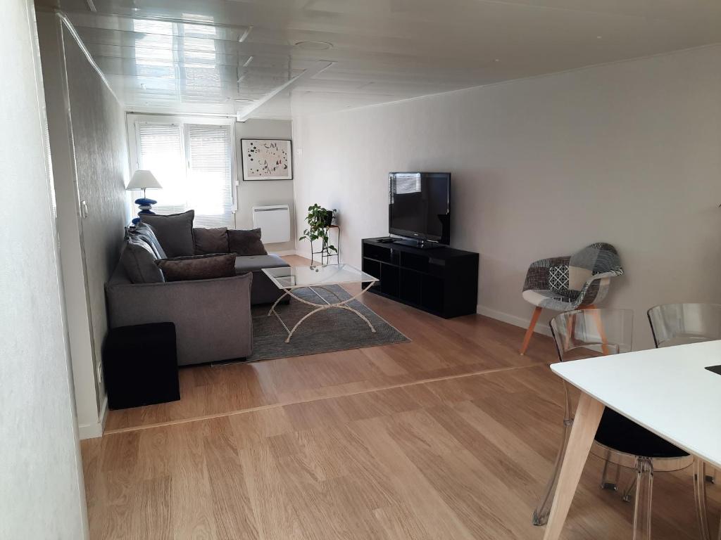 un salon avec un canapé et une télévision dans l'établissement appartement T3 quartier ARAGO, à Les Sables-dʼOlonne