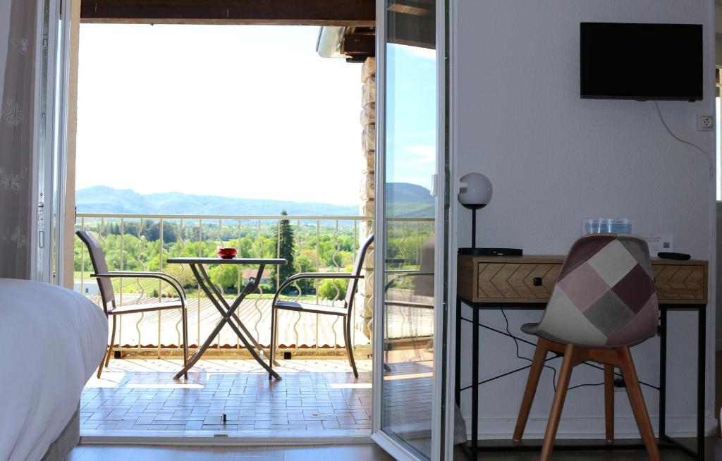een slaapkamer met een bed en uitzicht op een balkon bij Hôtel de Vacances de la Vignasse in Chandolas
