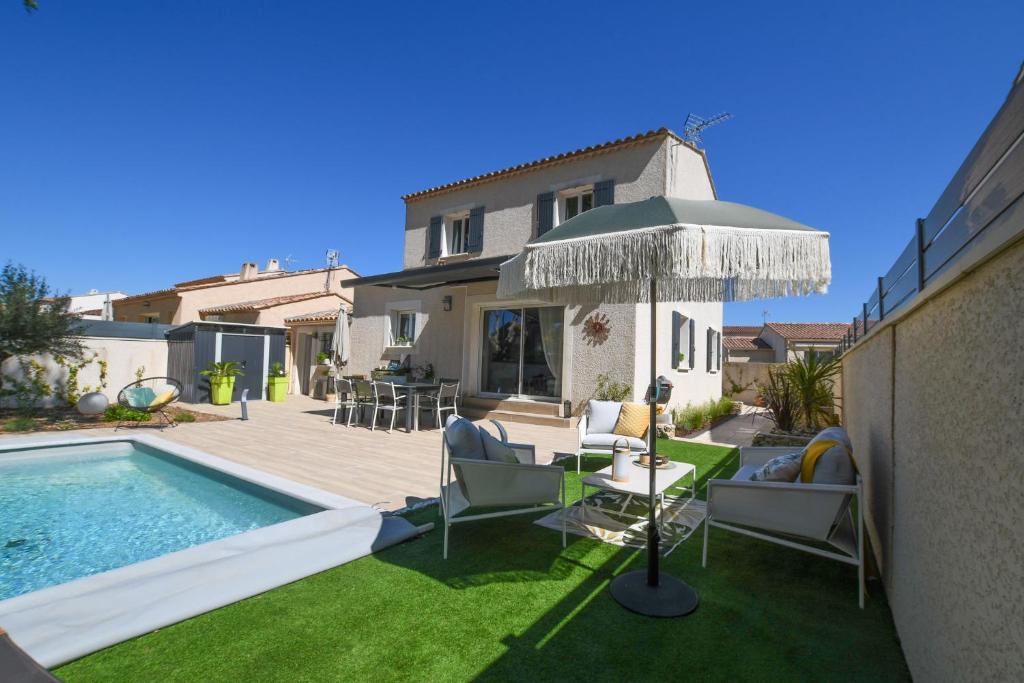 a backyard with a swimming pool and a house at Entre les Alpilles, la Mer, la Camargue, à huit kilomètres de ARLES ,Villa des jasmins ,piscine,3 chambres ,climatisation, wifi fibre in Raphèle