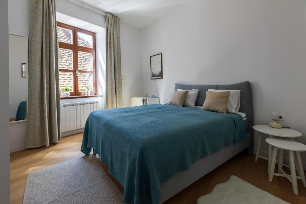 una camera da letto con un letto con una coperta blu di Apartment Nikola 4* a Zagabria