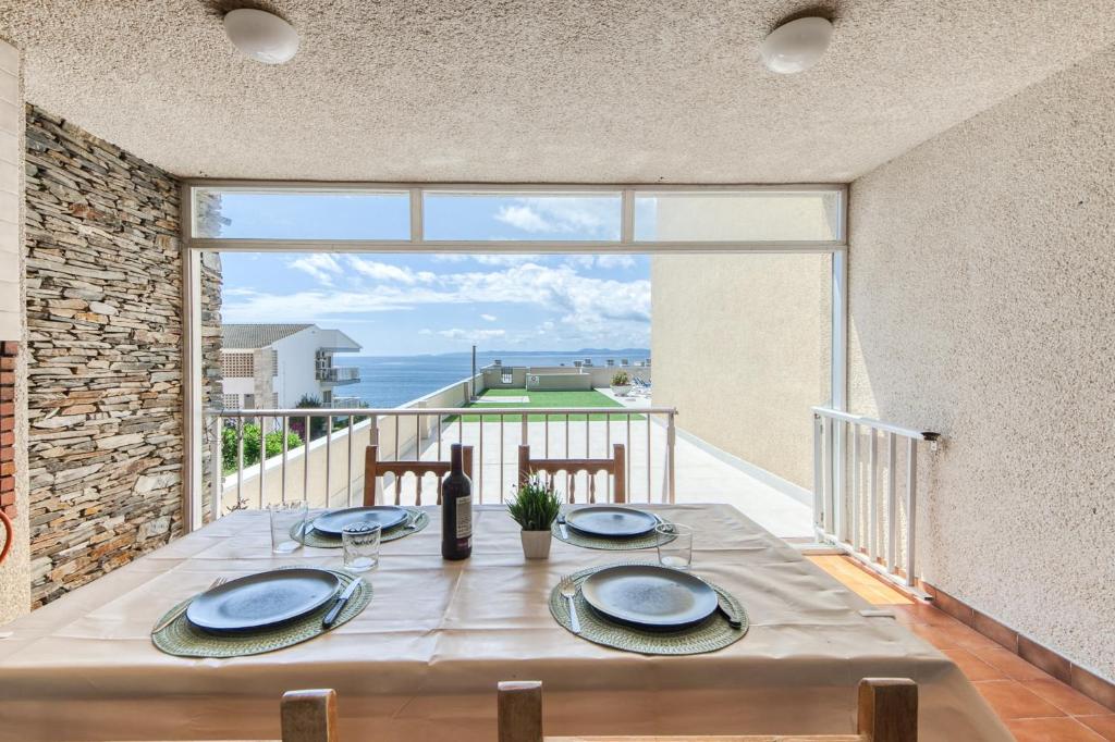 a dining room table with a view of the ocean at Dallas 2B Canyelles Roses - Immo Barneda in Roses
