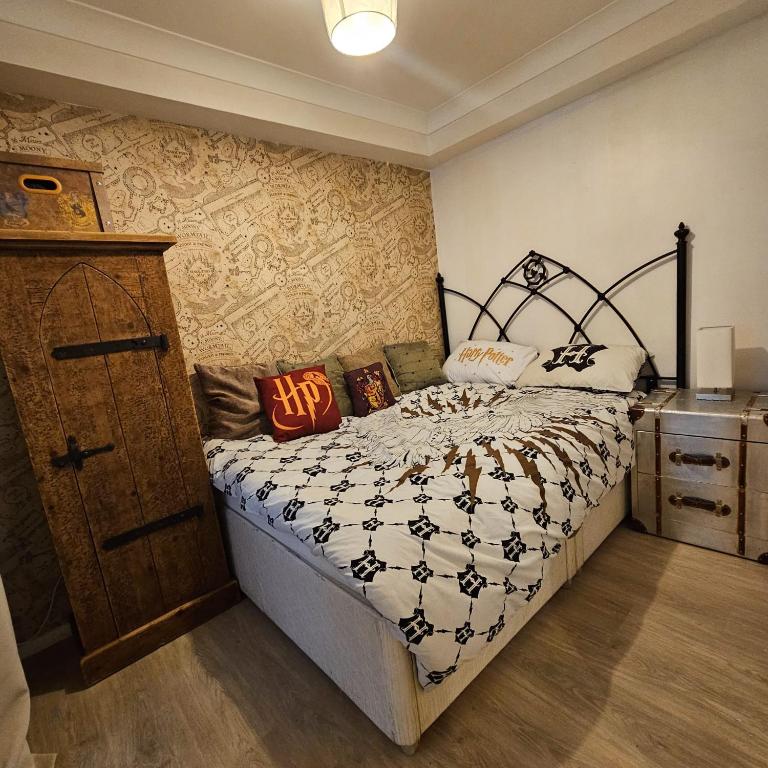 a bedroom with a bed and a dresser at Godricks Hollow House in Watford
