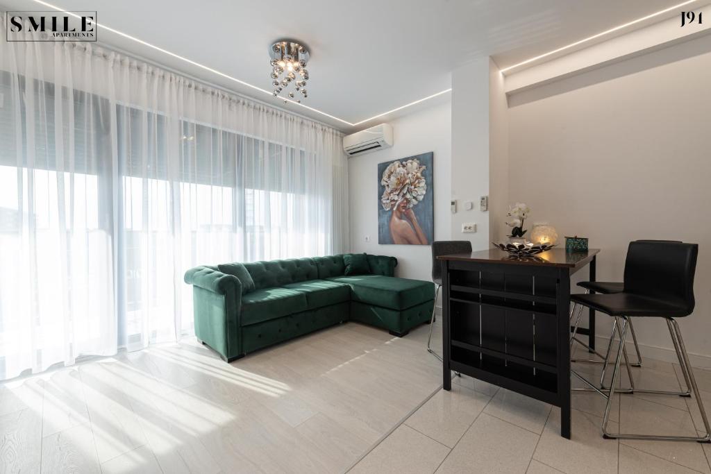 a living room with a green couch and a table at Smile Apartments in Bucharest