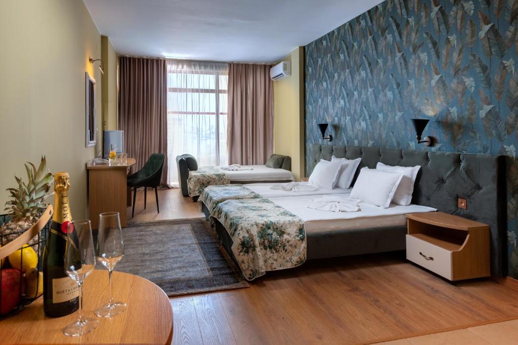 una habitación de hotel con una cama grande y una mesa en Hotel Avenue, en Sunny Beach