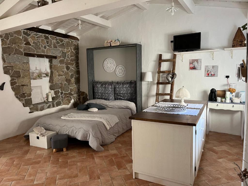 a bedroom with a bed and a stone wall at B&B Roseddu in Bitti