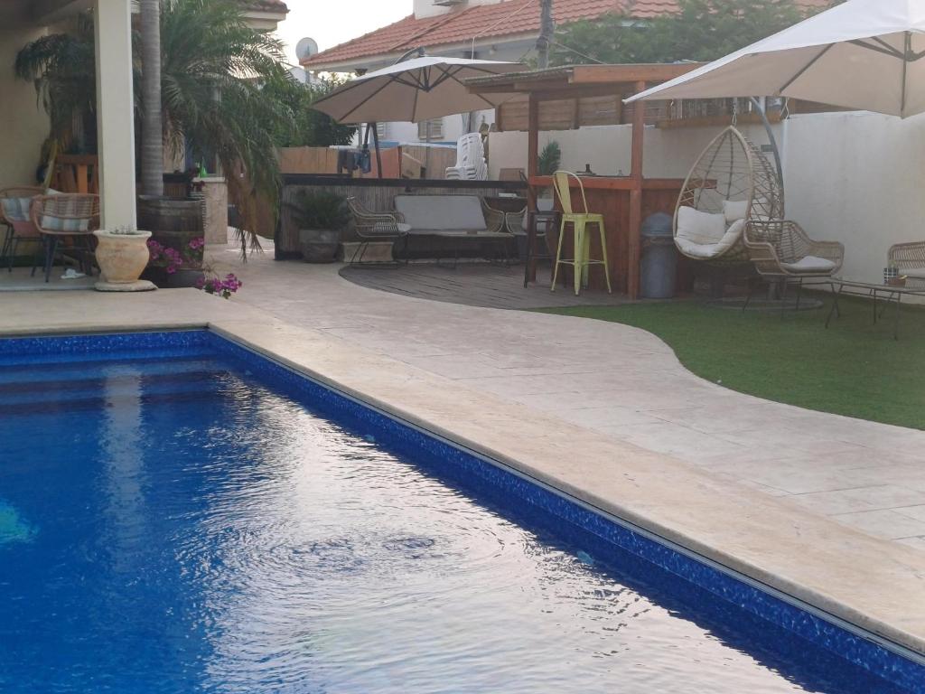 a swimming pool in front of a house with a patio at קאסה גומז in Kiryat Ekron